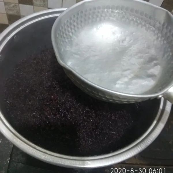 Setelah dikukus selama 10 menit, tuang dengan air panas lalu simpan ketan pada wadah