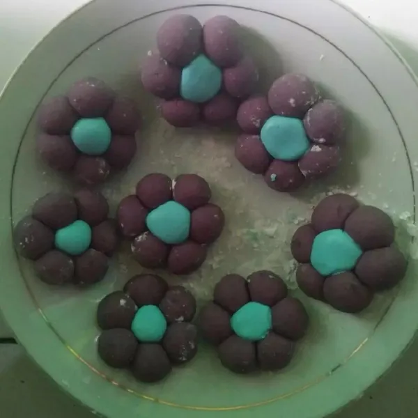 Sama seperti ubi ungu, bentuk bulat-bulat adonan biru (agak lebih besar sedikit dari warna ungu) kemudian ambil satu buah candil warna biru, lalu tempelkan dengan candil warna ungu di sekelilingnya. ( dengan sedit di oles air agar menempel. Lakukan hingga adonan habis ).