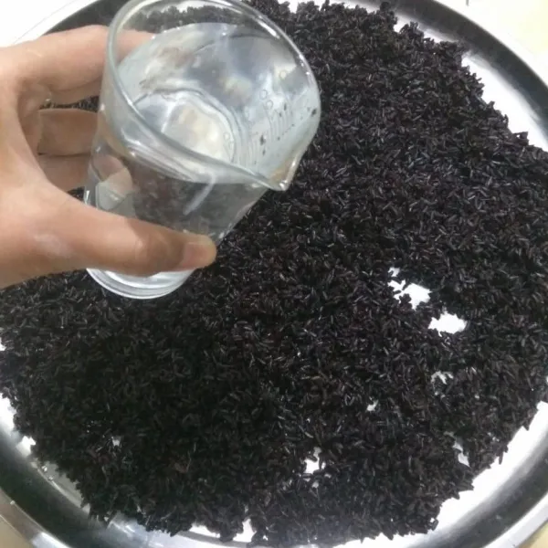 Simpan ketan pada wadah lalu siram dengan segelas air. Biarkan hingga air meresap pada ketan