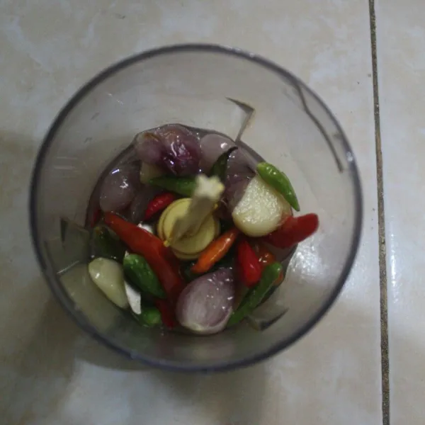 Haluskan bawang putih, bawang merah, kencur, dan cabai rawit.