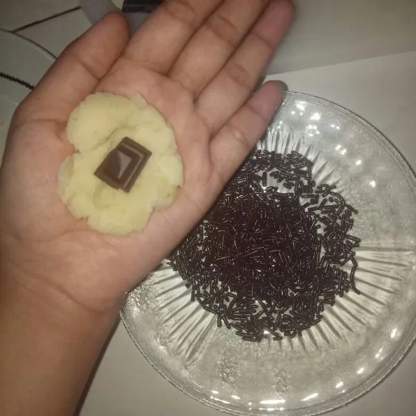 Ambil secukupnya singkong  yang sudah di haluskan. Isi dengan cokelat lalu gulingkan ke cokelat mesis sampai merata.