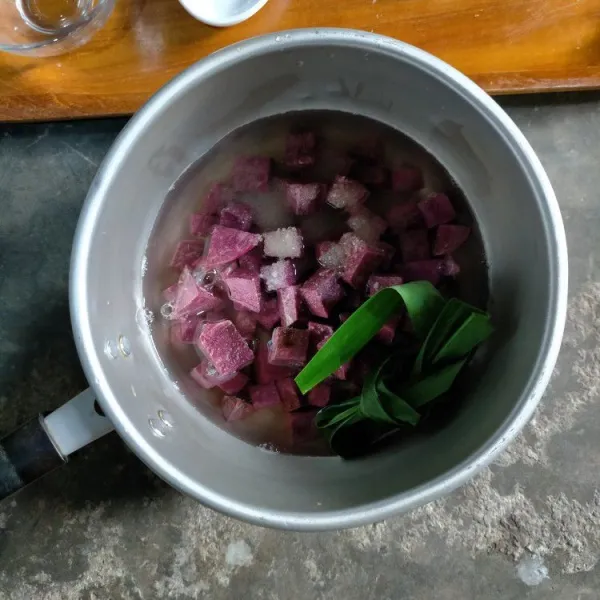 Siapkan panci. Masukkan ubi ungu yang sudah dipotong dadu kecil. Tambahkan air, garam, vanili, gula, dan daun pandan simpul. Rebus hingga ubi empuk.