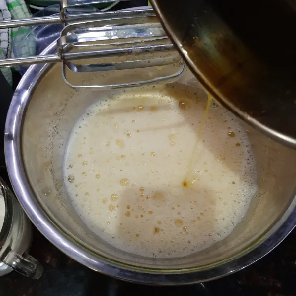 Tambahkan susu cair, vanilli dan butter cair, dan susu bubuk, kocok kembali hingga tercampur rata.
