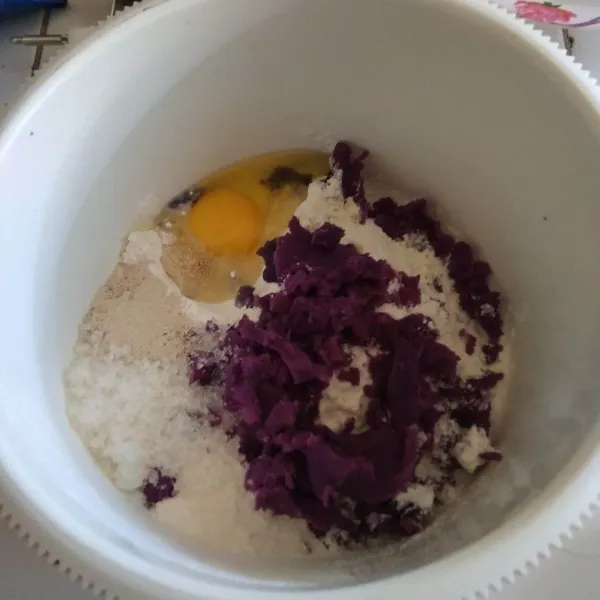 Dalam wadah campurkan terigu, ragi instan, susu bubuk, ubi ungu, gula dan telur. aduk rata.