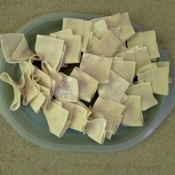 Siapkan kulit pangsit, masukkan secukupnya isi, kemudian lipat sesuai selera. Lakukan hingga kulit dan isi habis