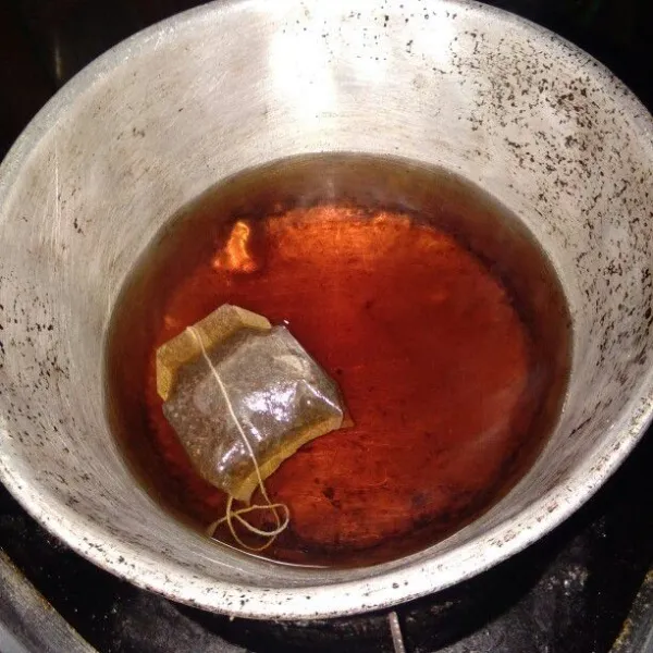 Masukkan teh instan. Aduk sampai teh berwarna merah pekat.