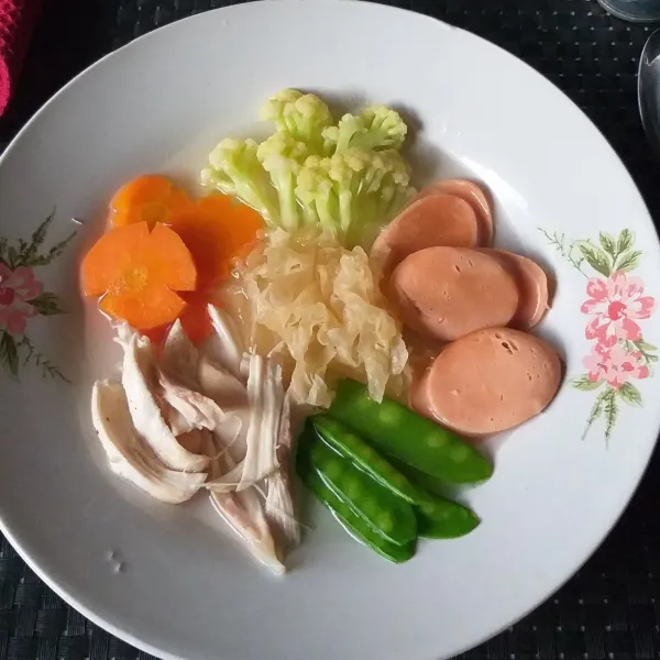 Penyajian : tata sayuran dan sosis di piring, beri suwiran ayam dan jamur, siram dengan kaldu. Sajikan.