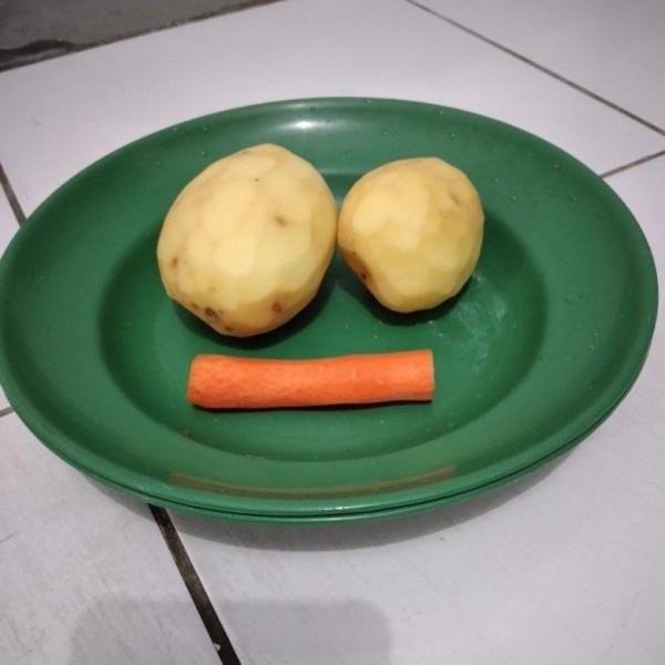 Kupas kentang dan wortel, cuci bersih.