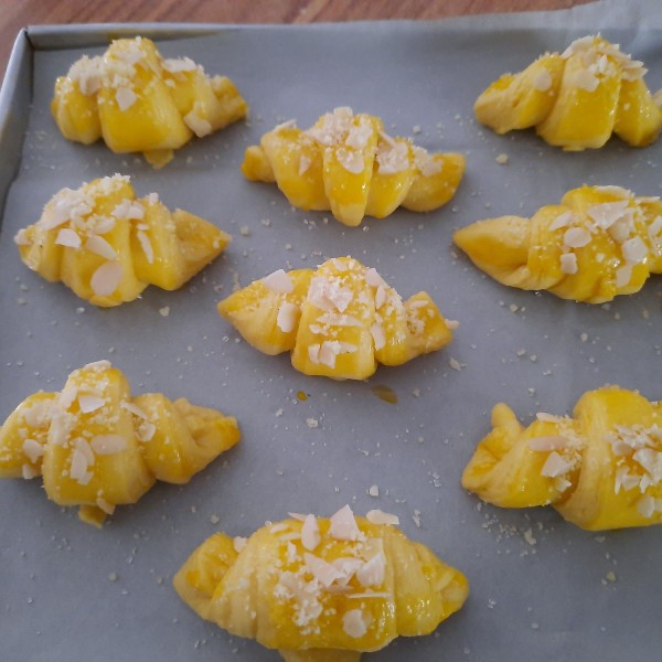 Untuk trakhir, giling adonan sampai ketebalan ½cm, lalu poting segitiga memanjang, dan gulung adonan seperti digambar. susun diloyang, biarkan mengembang 2x lipat. oles kuning telur, tabur parmesan cheese dan almond bubuk.