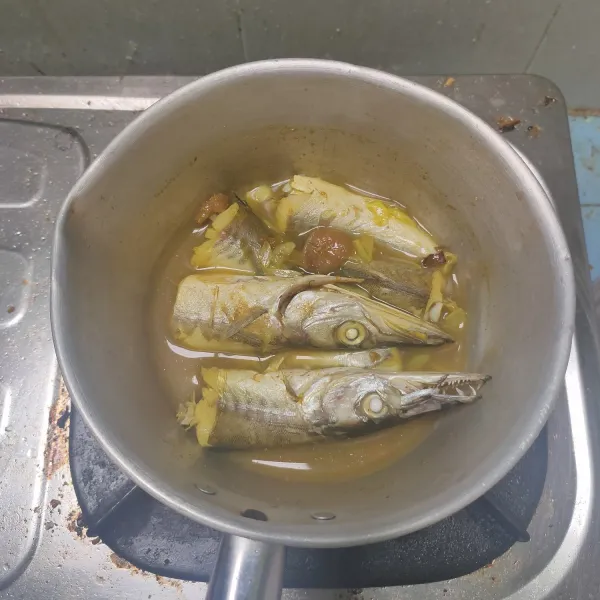 Masukkan ikan ke bumbu tersebut, masak hingga matang. Biarkan mendingin dan bumbu meresap.