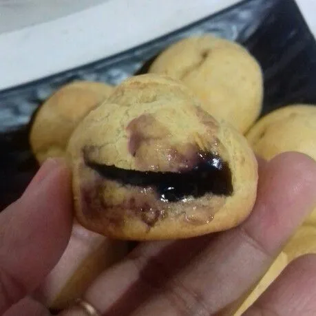 Gunting sedikit bagian sisi kulit soes, semprotkan selai bluberry ke dalamnya. beri toping coklat batangan yang ditim. Sajikan.