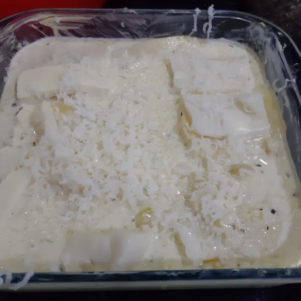 Oles pinggiran dengan mentega lalu susun kentang, siram dengan saus dan tutup dengan keju mozzarella. Lakukan berulang hingga habis. Tutup dengan alumunium foil.