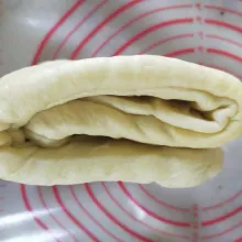 Lipat 1/3 bagaian atas ke tengah, 1/3 bagian bawah ke tengah, kemudian gilas memanjang.