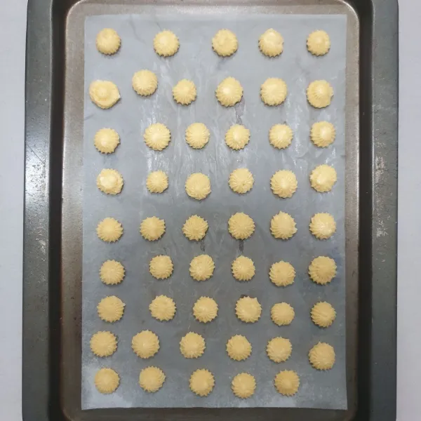 Semprotkan adonan di atas loyang yang sudah di alasi dengan Parchment paper.