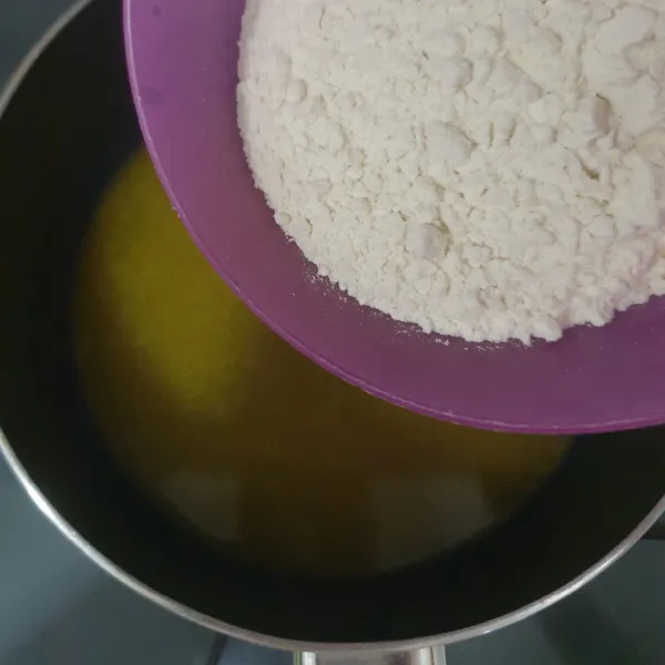 Masukan tepung terigu serbaguna, aduk cepat sampai tercampur rata.