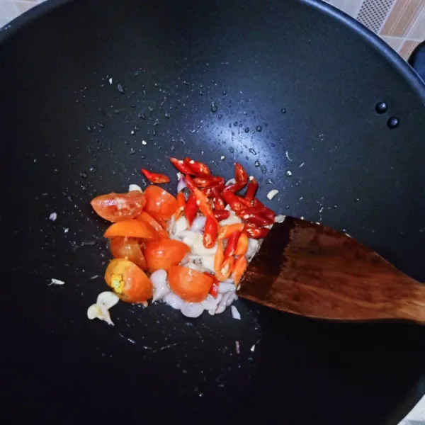 Panaskan minyak goreng. Tumis bawang putih sampai harum, lalu tumis bawang merah. Masukkan cabai merah, cabai rawit, dan tomat. Tumis sampai tomat sedikit layu.