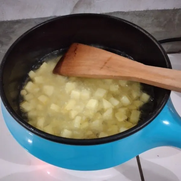 Goreng kentang dengan minyak panas.
