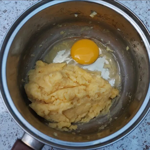 Masukkan telur satu persatu sambil diaduk dengan sendok kayu sampai rata.