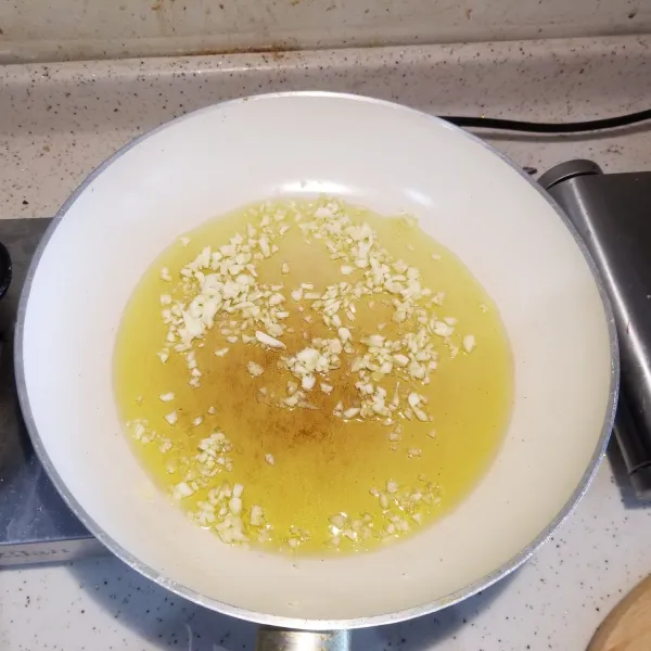 panaskan minyak zaitun dan tumis bawang putih hingga harum