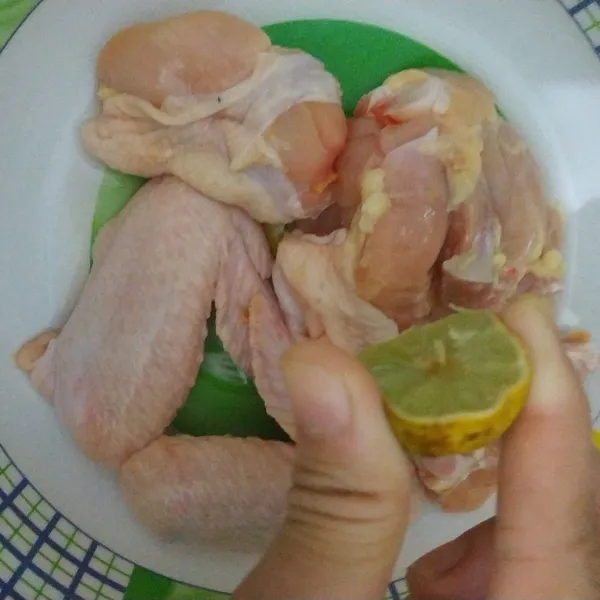 Beri air perasan jeruk nipis ke potongan daging ayam yang sudah dicuci bersih.