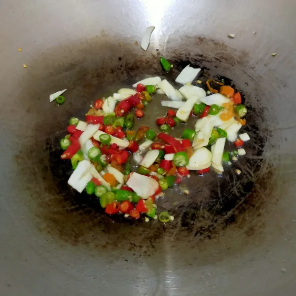 Panaskan minyak, masukkan bawang putih dan cabai yang sudah diiris, tumis hingga harum.