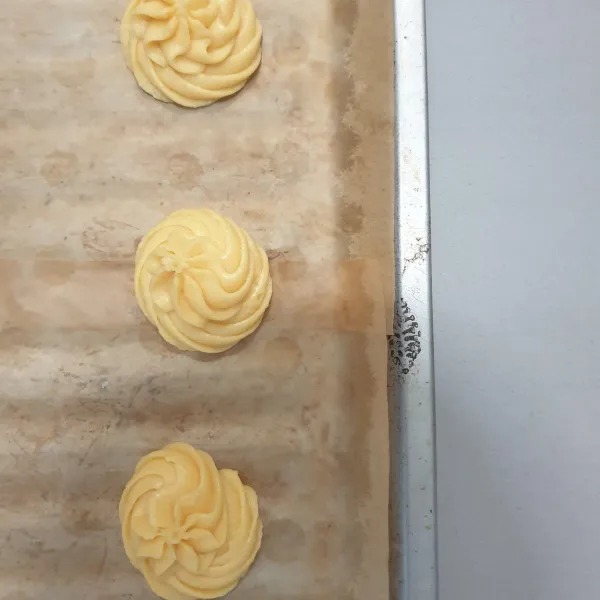 Semprotkan adonan keatas loyang yang sudah di alasi dengan Parchment paper.