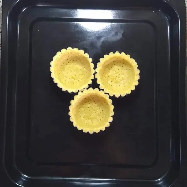 Cetak adonan dalam cetakan pie, tusuk-tusuk dengan garpu, lalu panggang sampai setengah matang, selama 15 menit.