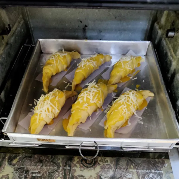 Kemudian oles dengan kuning telur, tambahkan keju parut, panggang selama 30 menit, angkat, siap disajikan.