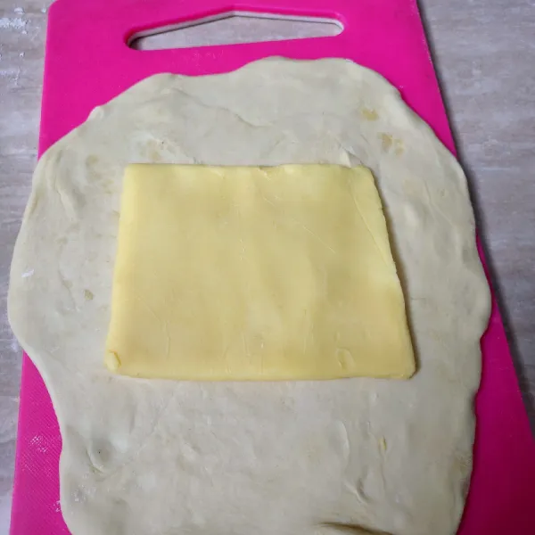 Letakkan adonan tepung, gilas tipis dan lebar, tambahkan korsvet, lalu bungkus rapat hingga menutupi semua bagian korsvet.