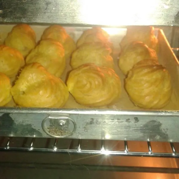 Panggang dalam oven yang sudah panas tadi selama 20-25 menit. Penting: Oven jangan dibuka-buka sampai adonan naik dan kering. Panggang hingga coklat kekuningan. Keluarkan dari oven lalu dinginkan dalam suhu ruang.
