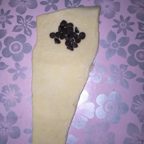 Potong pastry Croissant berbentuk segitiga memanjang, beri isian Chocochips secukupnya.