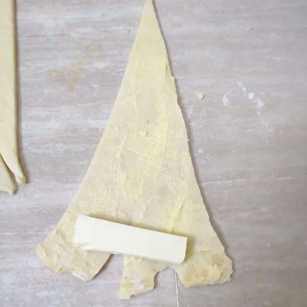 Ambil satu lembar kulit, oles dengan campuran margarin dan gula halus, tambahkan keju potong, lalu gulung.