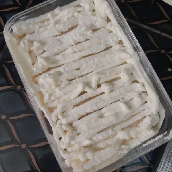 Beri whipped cream di atas roti secara merata
