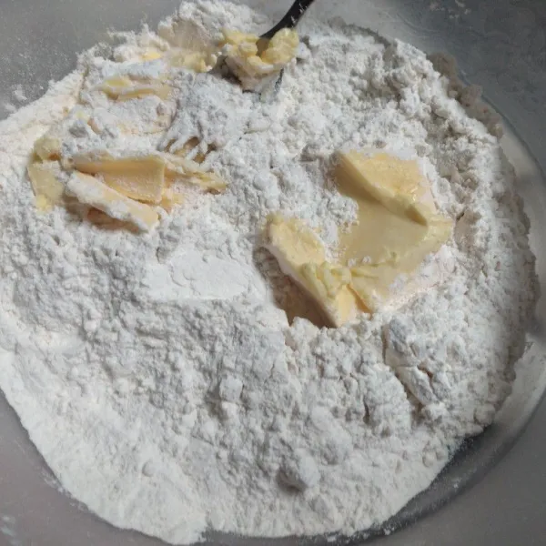 Campur jadi satu terigu, garam dan gula halus, aduk rata. masukkan margarin campur menggunakan garpu hingga bergerindil.