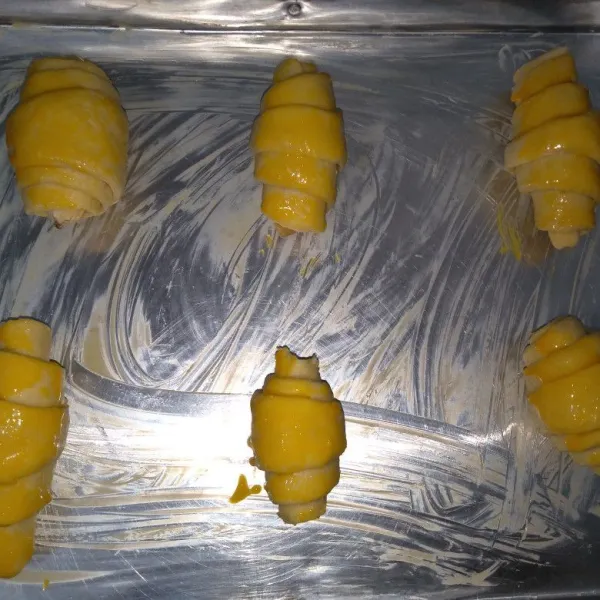 Olesi dengan kutel dn beri taburan gula diatasnya. panaskan oven terlebih dahulu dengan suhu 200°C. turunkan suhu menjadi 180°C kemudian panggang Croissant selama 45 menit menggunakan api atas bawah.