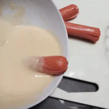 Celup bagian sosis yang tidak dibelah ke adonan basah, gulingkan ke breadcrumbs (tepung roti) lalu goreng sampai matang (breadcrumbs bisa diskip jika tidak ada)