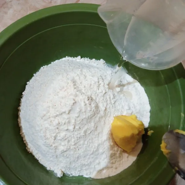 Campur terigu dan blueband, tuang perlahan air dingin uleni sampai kalis.