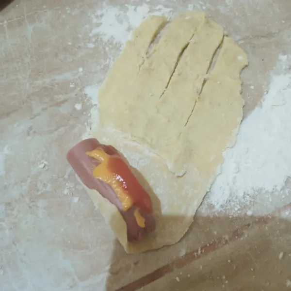 Letakkan sosis, mayonise dan saus sambal diatasnya. Gulung/bentuk sesuai selera.