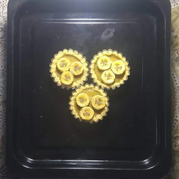 Masukkan adonan isi ke dalam pie yang sudah di panggang setengah matang, tambahkan potongan pisang di atasnya.