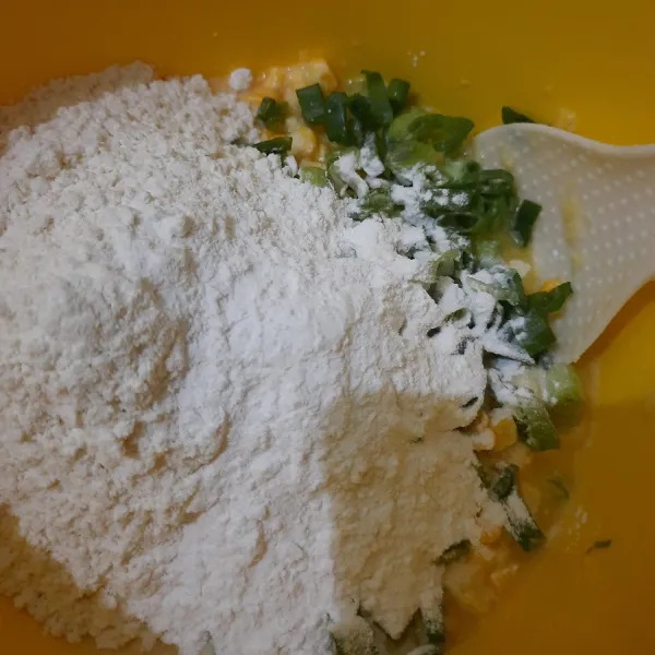 tambahkan tepung terigu dan tapioka. masukkan daun bawang, garam dan kaldu jamur. aduk rata. tes rasa.