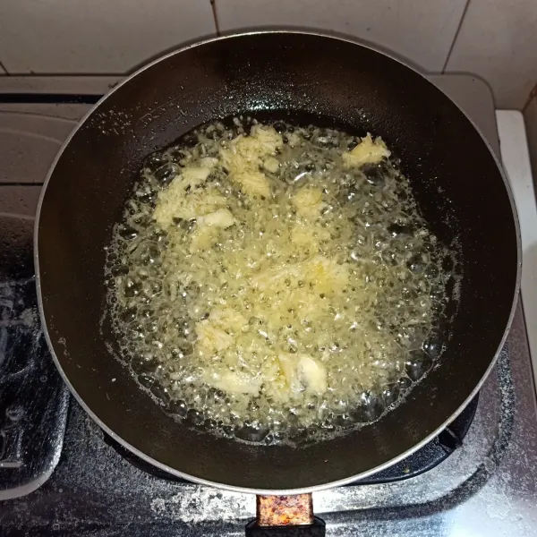 Panaskan minyak dan goreng bawang putih yang sudah diparut hingga harum dan warnanya berubah menjadi kecokelatan