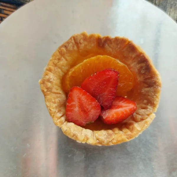 Susun potongan buah di atas kulit pie.