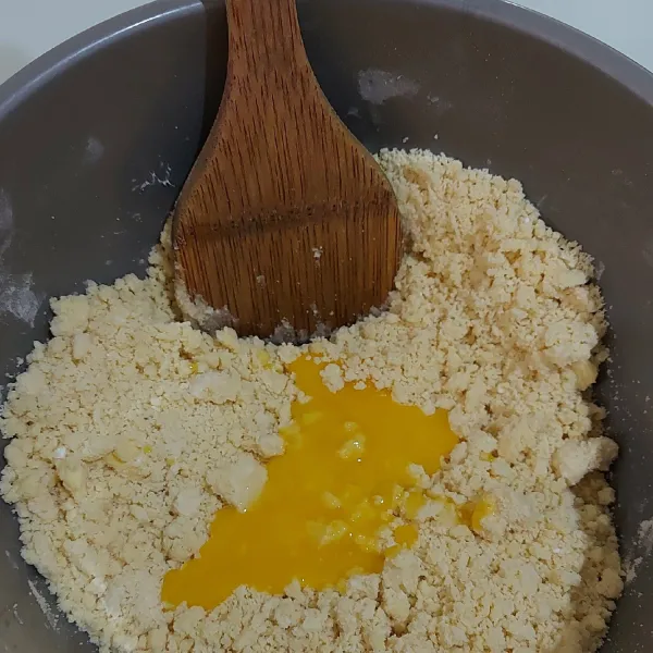 Masukkan kuning telur. Aduk rata menggunakan sendok kayu.