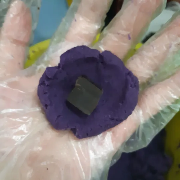 Ambil sedikit adonan, tambahkan potongan DCC ke dalamnya. Tutup dan bentuk bulatan