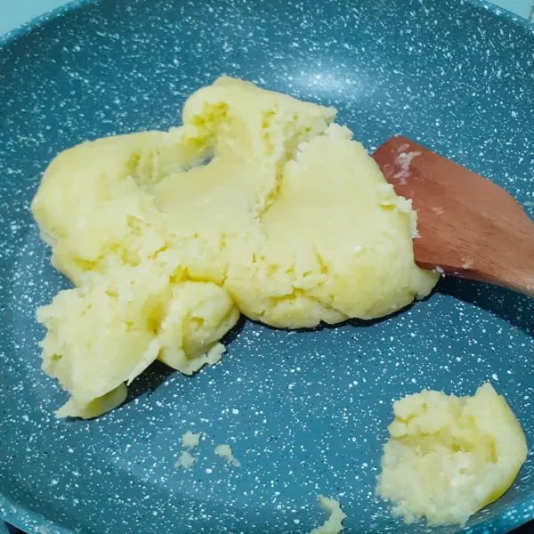 Tambahkan terigu dan gula halus. Aduk hingga tercampur rata. Nyalakan api dan masak hingga kalis. Matikan api. Tunggu hingga adonan hangat.