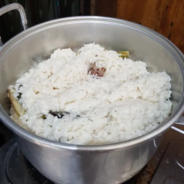Masukkan nasi yang sudah dimasak dengan bumbu ke dandang yang sudah panas, masak dengan api sedang selama 25-30 menit