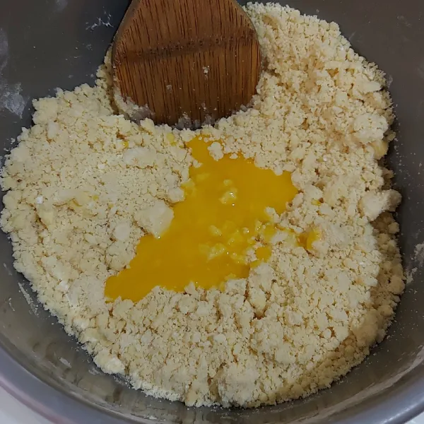 Masukkan kuning telur. Aduk rata menggunakan sendok kayu.