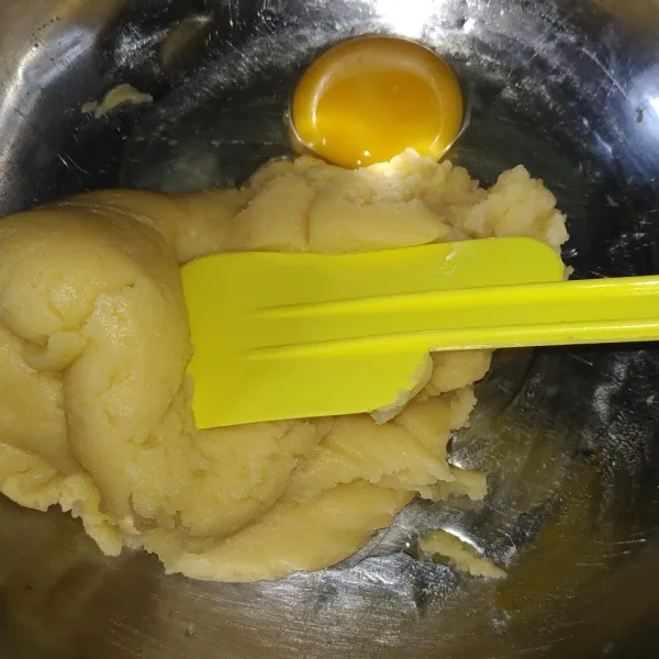 Matikan kompor. Tambahkan tepung. Aduk hingga adonan hangat. Masukkan telur satu persatu sambil diaduk. Kemudian panaskan lagi adonan sebentar.