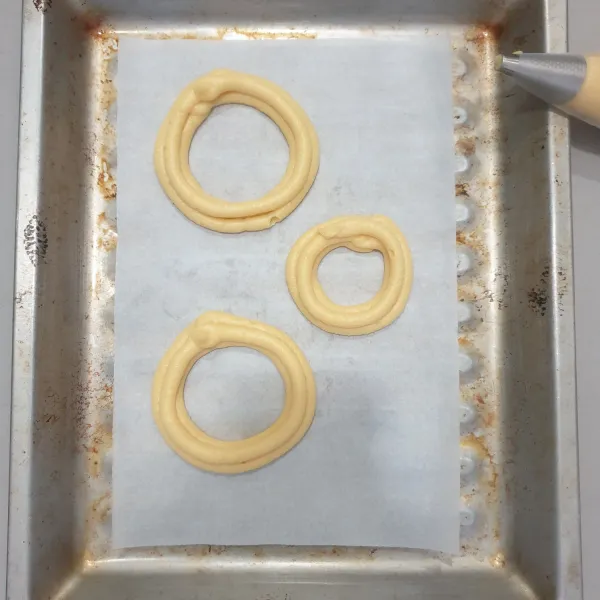 Semprotkan adonan membentuk lingkaran. Panaskan oven selama 15 Menit dengan suhu 190 derajat Celcius, panggang kue selama 20 Menit setelah itu turunkan suhu pada 170 derajat Celcius panggang kembali selama 20 menit angkat dan dinginkan.