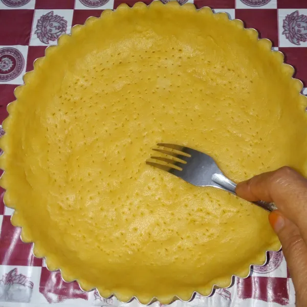 Cetak ke dalam cetakan pie yang sudah diolesi margarin lalu tusuk tusuk dasarnya menggunakan garpu.